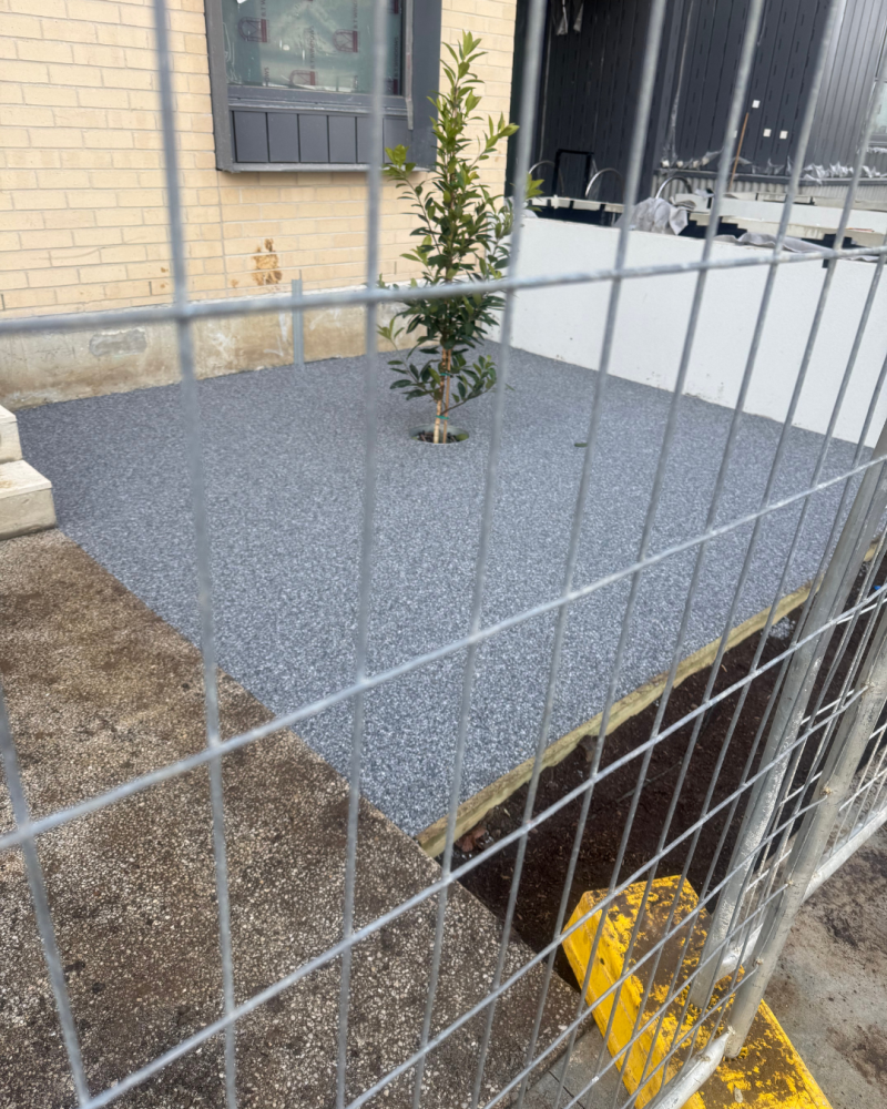 StoneSet permeable paving corner, with an adjoining unfinished area fenced off"
