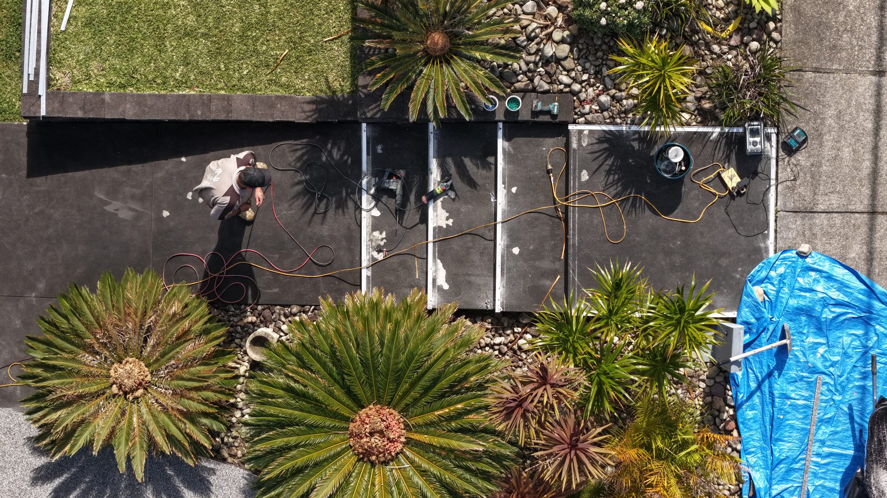 Aerial view of a pale StoneSet resin-bound pathway winding through a landscaped garden with palms and tropical plants